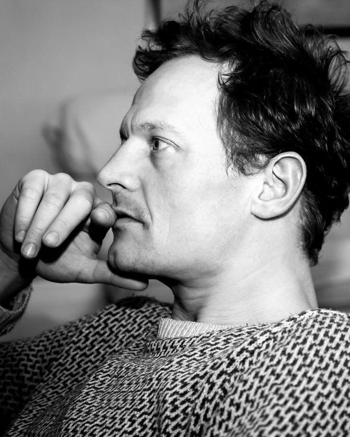 Black and white profile portrait of photographer Marcus Vallance, hand to his mouth